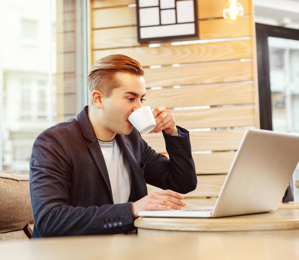 Drinking coffee at laptop